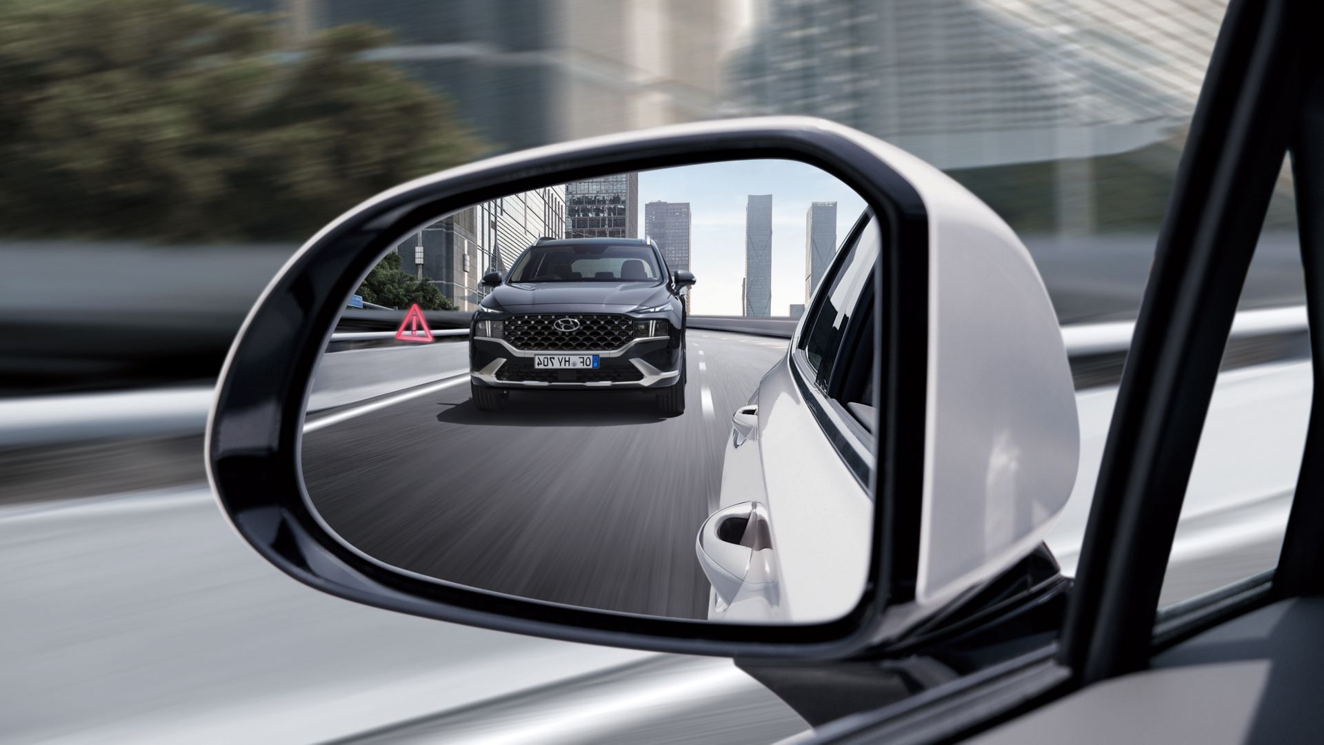 The side mirror of the new Hyundai Santa Fe Hybrid 7 seat SUV reflecting another Santa Fe Hybrid.